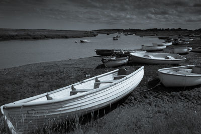 Boats moored on beach against sky