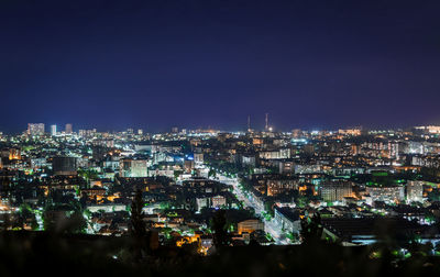 High angle view of illuminated city buildings against clear sky