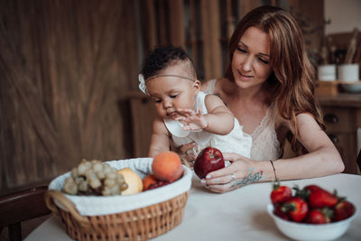 Mother and daughter against fruits