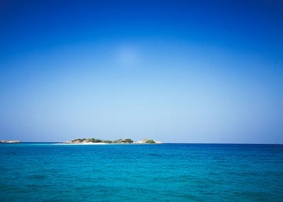 Scenic view of sea against clear blue sky