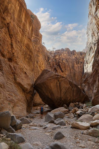 Man with backpack walking on wadi ghuweir canyon, jordan