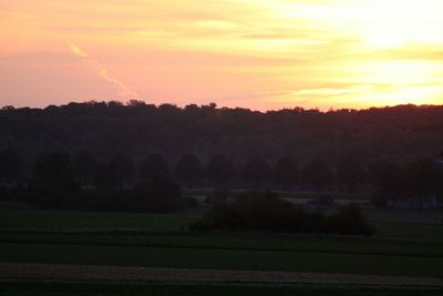 Scenic view of field against sky during sunset