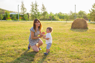 Full length of mother and girl on field