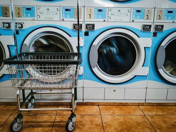 Shopping cart against washing machine at laundromat