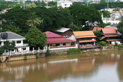 Houses by river and buildings in city