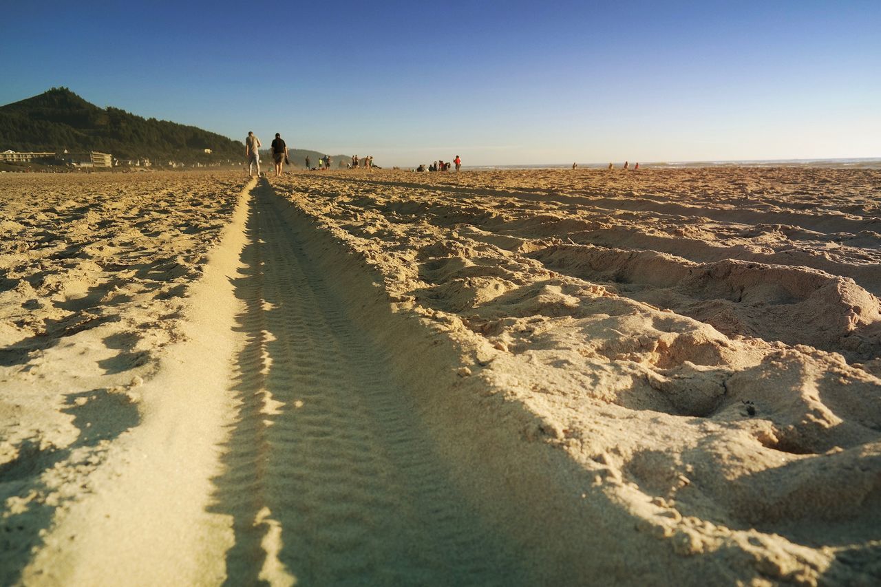 Panoramic view of people on beach against clear sky