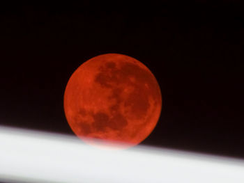 Red moon against sky at night