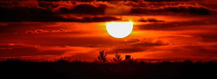 Scenic view of silhouette landscape against orange sky