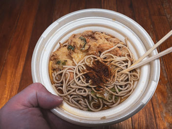 High angle view of hand holding bowl of food