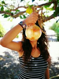 Close-up of young woman against tree