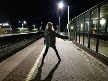 Woman standing on railroad track at night