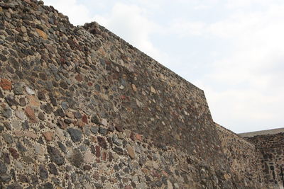 Low angle view of stone wall against sky