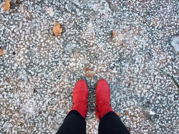 Low section of person standing on footpath during winter