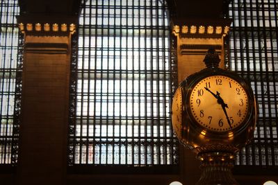 Low angle view of illuminated clock on window