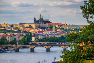 Bridge over river against buildings in city