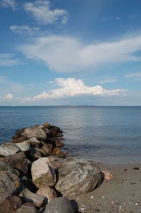 Rocks at beach against sky