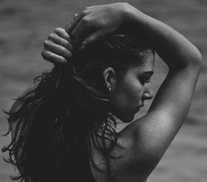 Close-up of young woman with hands in water