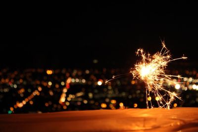 Close-up of burning sparkler against clear sky at night