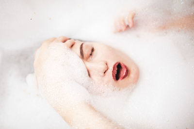 Close-up of young woman with eyes closed in bathroom