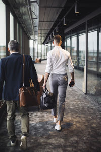 Rear view of men walking in bus