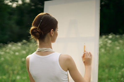 Portrait of woman holding camera outdoors