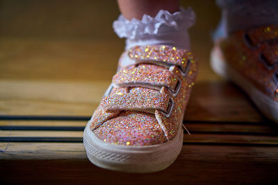 A close up of a pink sparkly shoe