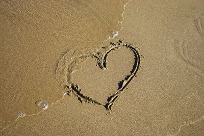 Close-up of heart shape on sand