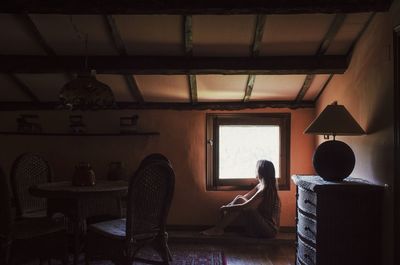 Rear view of man sitting in room