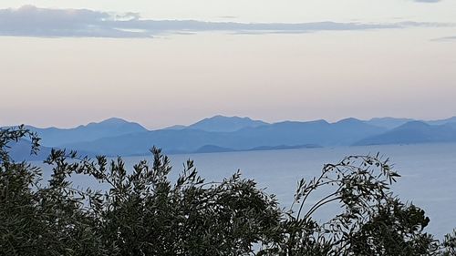 Scenic view of sea and mountains against sky