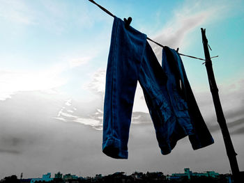 Low angle view of clothes drying against blue sky