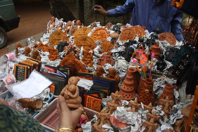 Midsection of man selling figurines in market