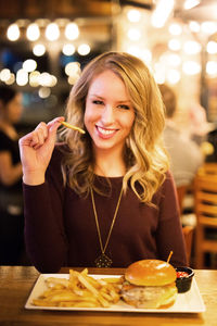 Portrait of a smiling young woman eating food