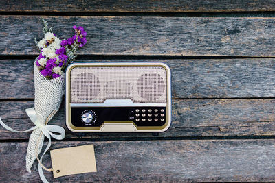 Directly above shot of bouquet with radio on wooden table