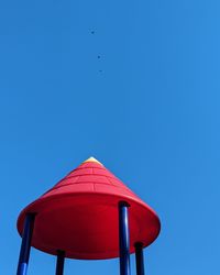 Low angle view of bird flying against clear blue sky