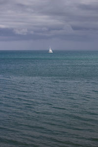 Sailboat sailing on sea against sky