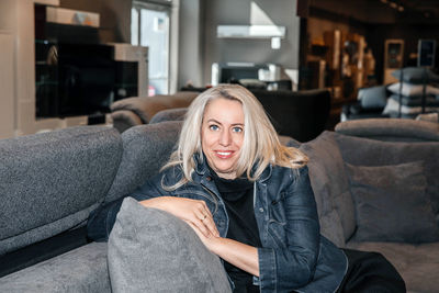 Stylish woman with gleaming silver hair relaxed in a modern furniture store