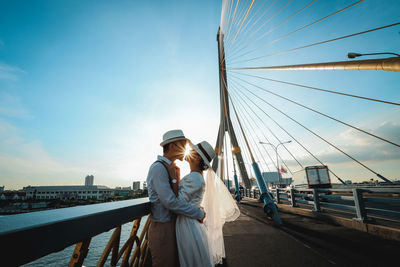 Woman standing on bridge against sky