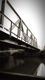 Train on bridge over river against sky