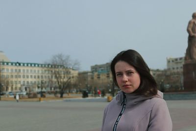 Portrait of woman standing against clear sky
