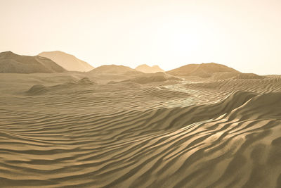 Sand dune in desert against clear sky