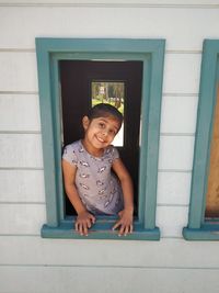 Portrait of smiling girl against door
