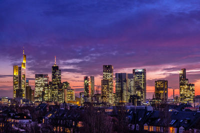 Illuminated cityscape against sky at dusk