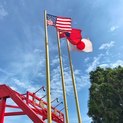 Low angle view of flag against blue sky