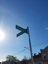 Low angle view of road sign against clear blue sky