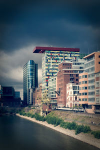 Buildings by road against sky in city