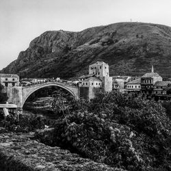 Arch bridge over mountain against sky