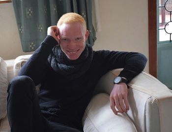 Portrait of smiling man sitting on sofa