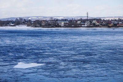 Scenic view of sea by city against sky