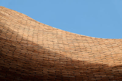 Low angle view of wicker basket against clear blue sky