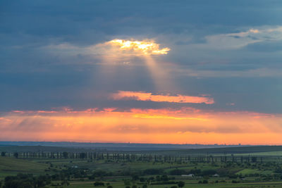 Scenic view of field against sky at sunset